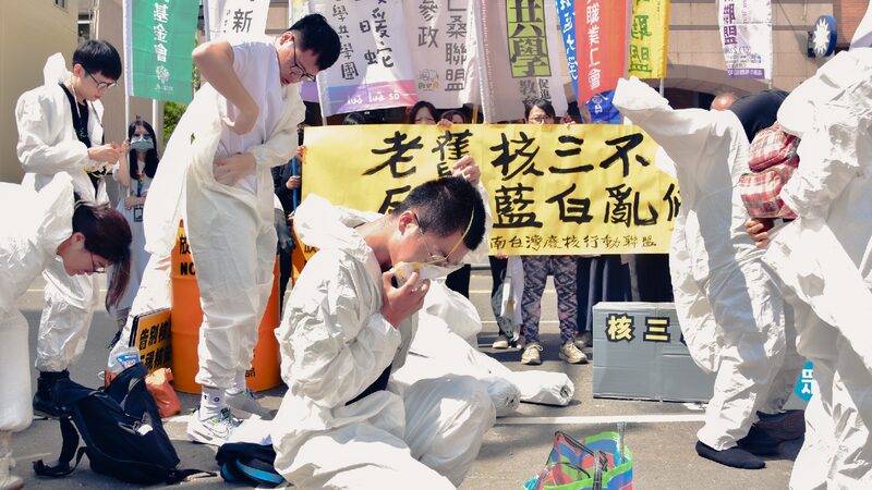 記者會上，志工們穿上白色防護衣與口罩，演出核災行動劇