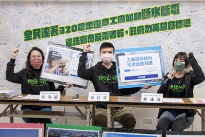 地球公民的員工在記者會舉起手舉版，上面寫著「違章工廠該拆就拆，污染該退就退」